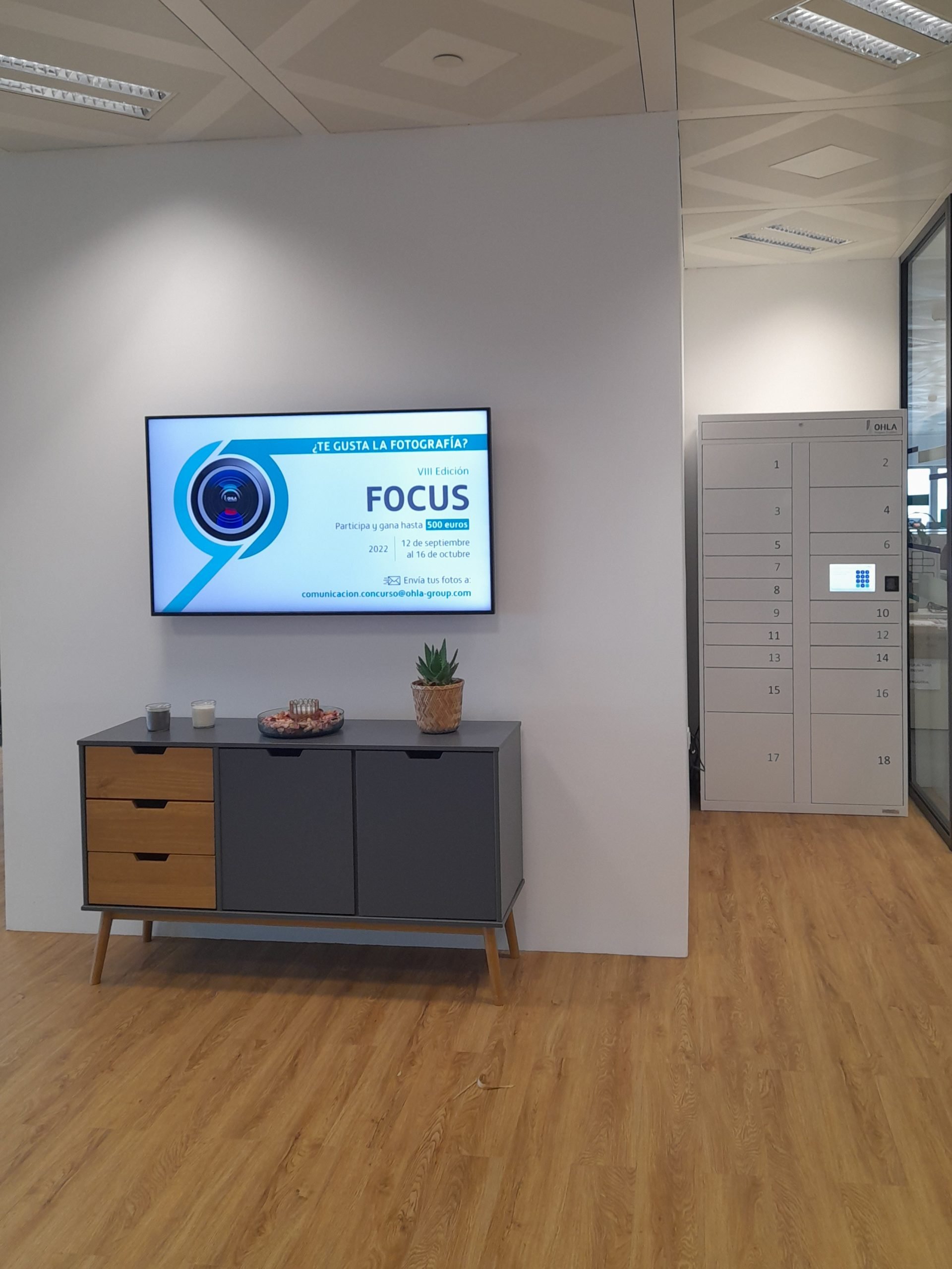 Taquilla inteligente de OHLA Group junto a la pantalla de la zona de coworking