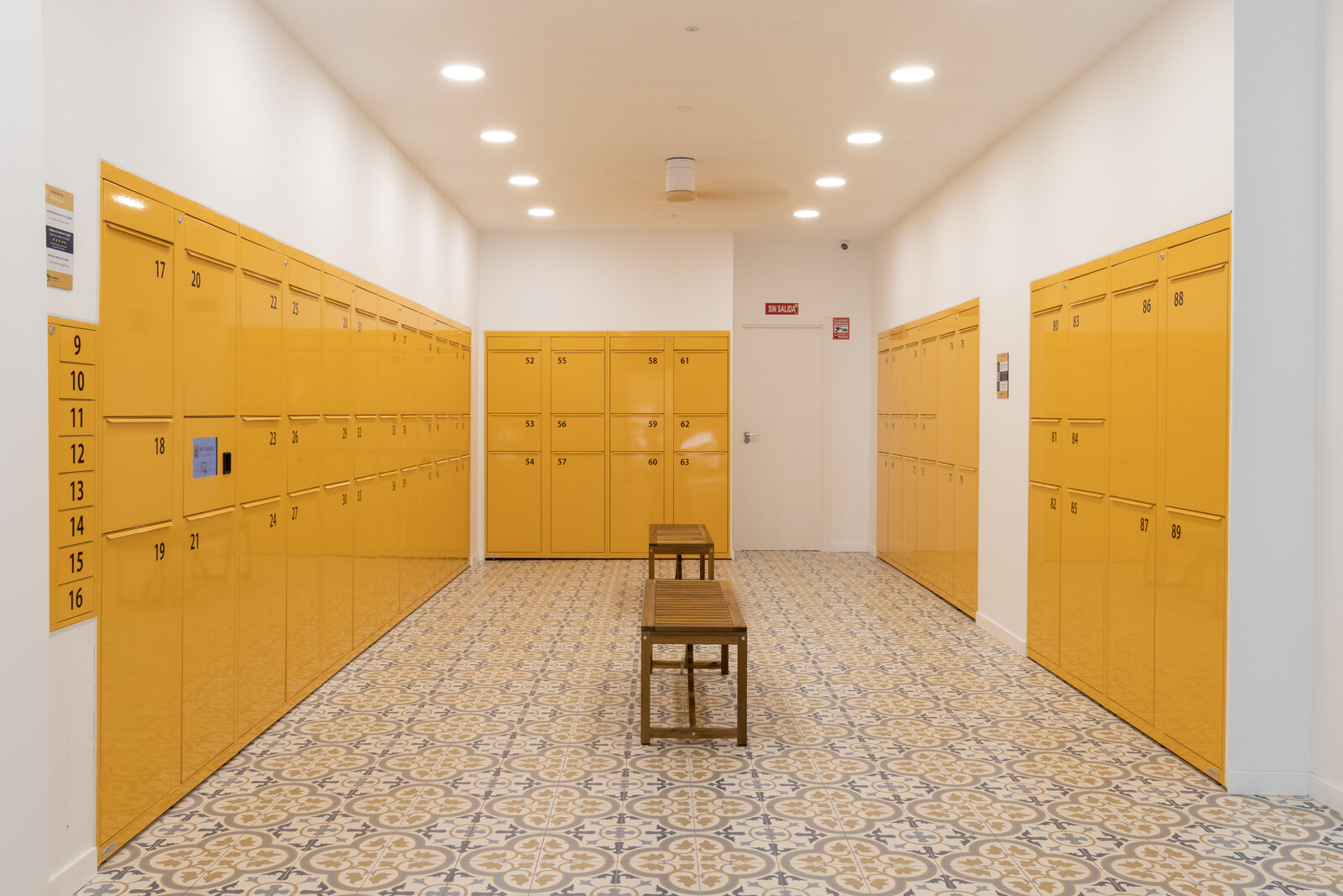 Sala de consignas amarillas de BeLockers Valencia, con banco central