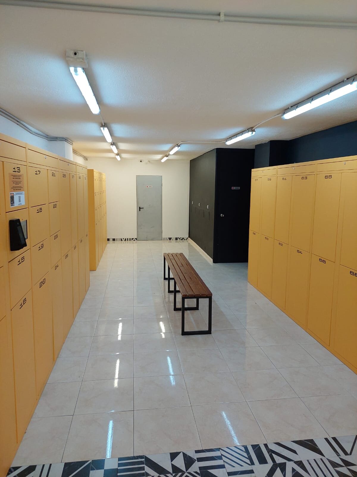 Pasillo de taquillas amarillas de Mallorca Lockers hacia la entrada