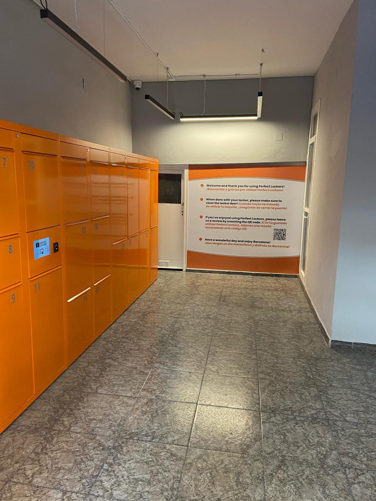 Pasillo de taquillas naranjas de Perfect Lockers hacia la entrada
