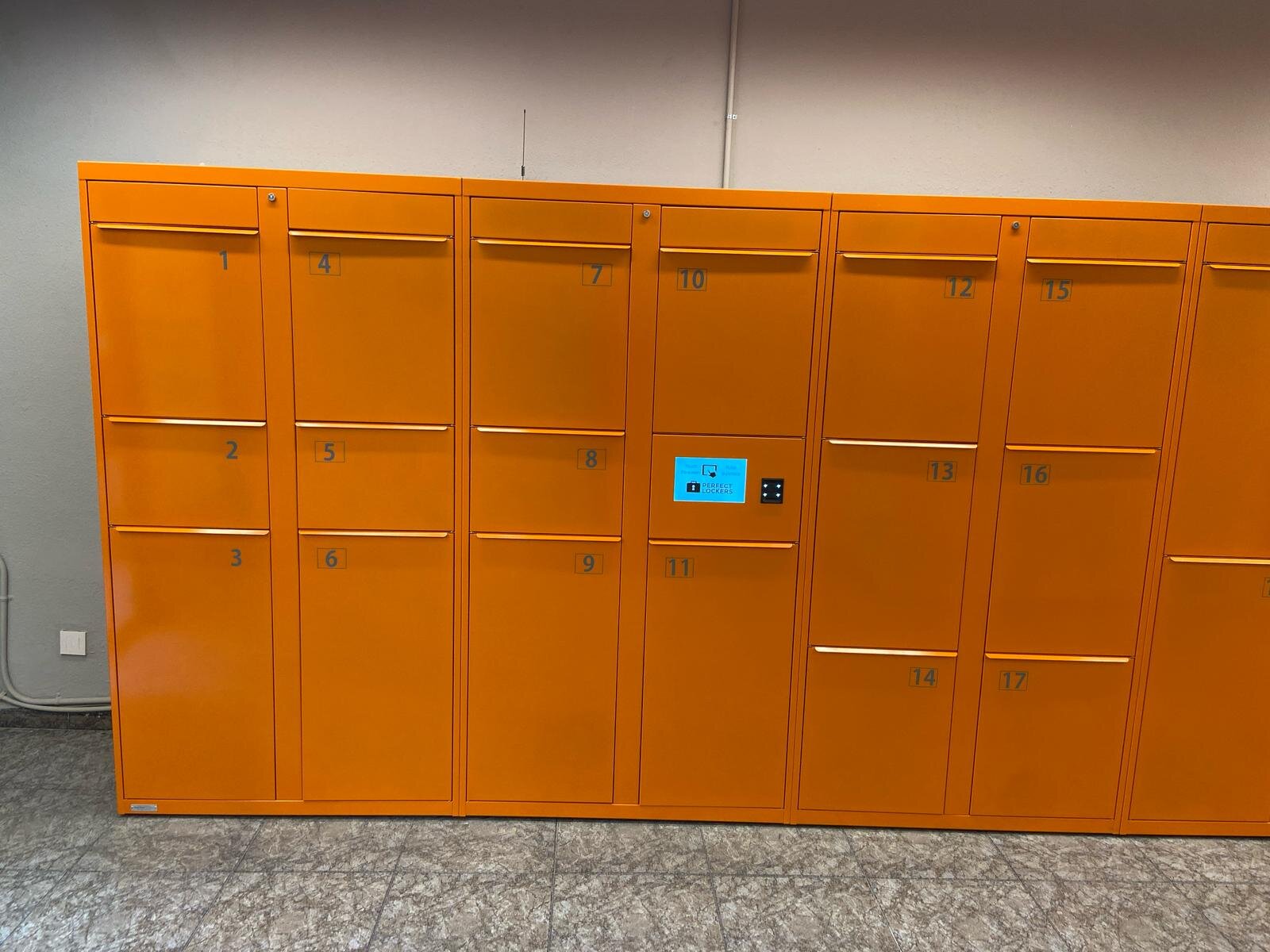 Taquillas naranjas de Perfect Lockers con la pantalla en el módulo central