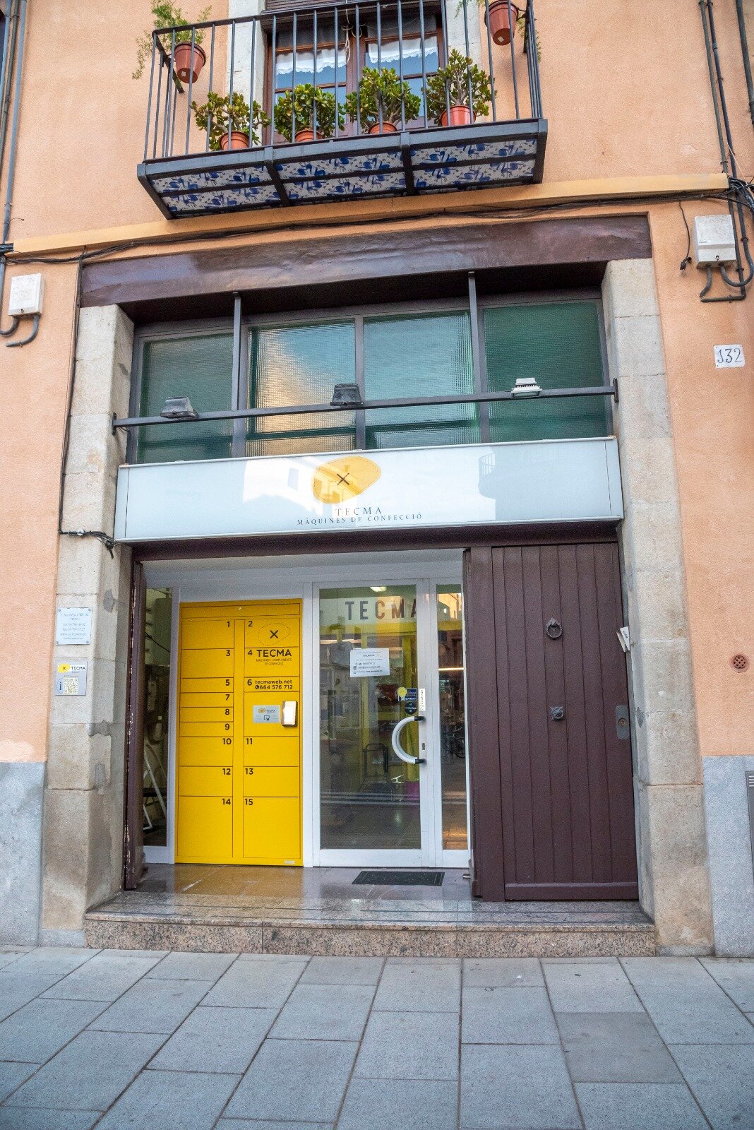 Fachada de TECMA en Mataró con la taquilla amarilla junto a la puerta