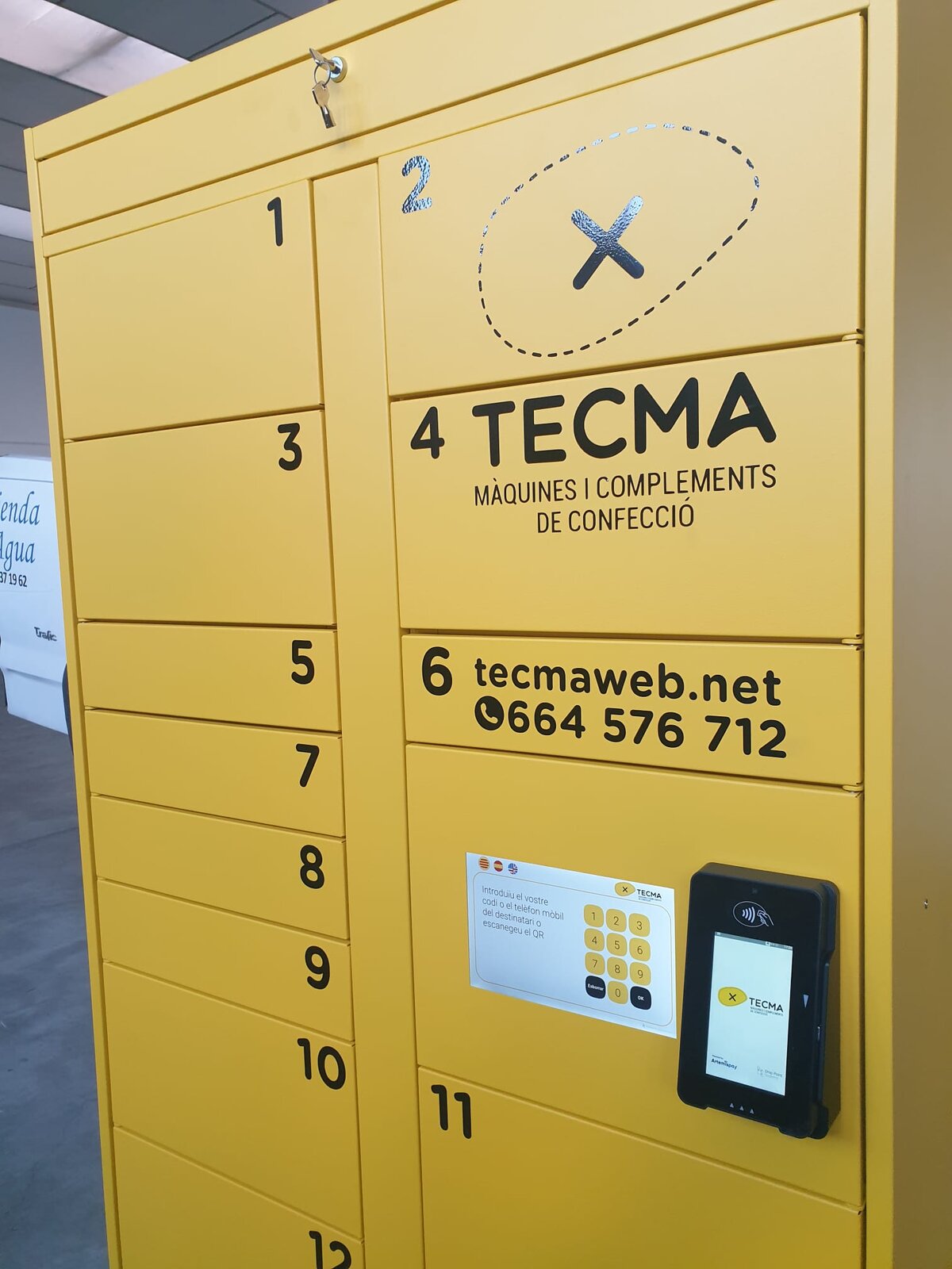 Taquilla amarilla de TECMA con el vinilo, la pantalla y el terminal de pago